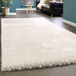 Ce tapis shaggy à poils hauts très doux couleur blanc neige associé à des meubles foncés trouvera également parfaitement sa p ...