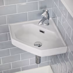 Ce lavabo d'angle suspendu en céramique est idéal pour les petites salles de bains et les toilettes exiguës, son style dit ré ...